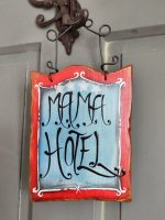 Drevená tabuľka s nápisom "Mama Hotel" na dverách, ideálna ako vtipný dekor pre domácnosť alebo darček pre mamu.